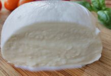 Mozzarella di bufala DOP, costi in salita ma prezzi fermi: il Consorzio non ritocca i listini Mozzarella di bufala su un piano di legno
